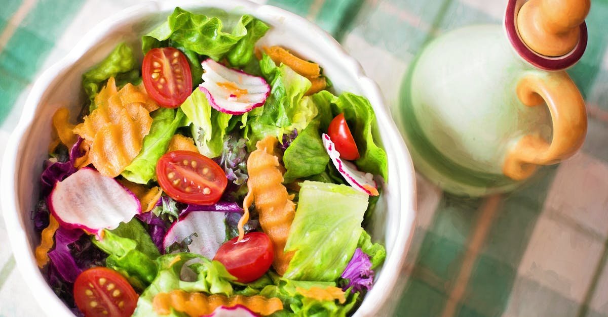 Colorful fresh vegetable salad with cherry tomatoes in a white bowl.